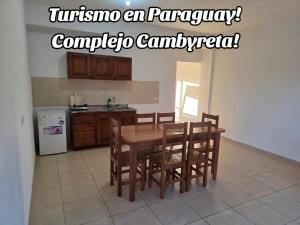a kitchen with a table and chairs and a refrigerator at Complejo Cambyreta Alojamiento temporario para 7 personas Encarnación Cerca de Playa San Jose in Cambyretá