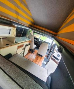 an interior view of an rv with chairs and a desk at Retro Camper Hire in Dublin
