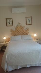 a bedroom with a large white bed with two tables at Gaerwood B&B in Keith