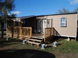 ein Haus mit einer Holzterrasse mit einem Haus in der Unterkunft Blue Camargue - Le Grau du Roi in Le Grau-du-Roi