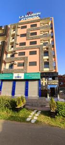 um prédio alto de apartamentos com inscrições na lateral. em APPART-HOTEL La MAISON ATTAWBA 2 em Beni Mellal