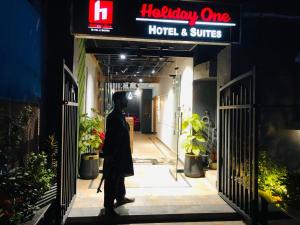 un uomo sta entrando in un hotel e suite di Holiday One Hotel & Suites a Karachi Altre 6 foto