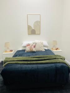 a bedroom with a bed with a green blanket at The Club Hotel Collie in Collie +49 photos