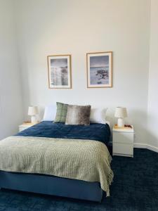 CollieにあるThe Club Hotel Collieのベッド、ナイトスタンド2台、ランプ2個を備えた寝室