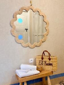 a mirror on a wall above a table with a basket at Riad El Badun in Marrakesh