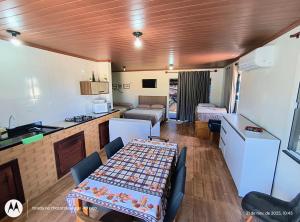 a kitchen and a living room with a table in a caravan at Acomodação Cambirela in Palhoça