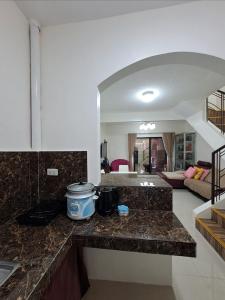 una cucina con piano di lavoro e un soggiorno di Janice Place a Marilao