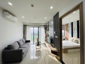 a living room with a couch and a bed and a mirror at JULY Homestay Nera huế in Thôn Văn Dương