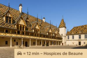 Ladoix SerrignyLes Nuits en Grands Crus Appartement cosy, près de Beaune, au cœur des vignes的一座大型建筑,设有瓷砖屋顶