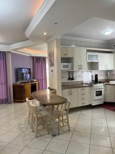 Una cocina con una mesa y sillas en una habitación. en Apto a 80 metros do mar para 8 pessoas, en Itapema