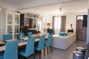 ヴォロクリーニにあるComfy room with sea view in Villa private poolのリビングルーム(テーブル、青い椅子付)