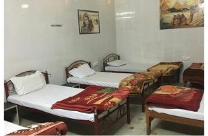 Hotel Al-raya Jaisalmer في جيلسامر: مجموعة من ثلاثة أسرة في غرفة