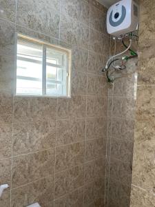 Un baño con ducha con ventana. en ELLEX SLEEVES APARTMENTs, en Ibadán