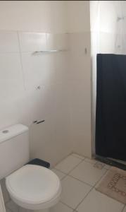 イリェウスにあるAP aconchego de Ilhéusの白いバスルーム(トイレ付)、テレビが備わります。