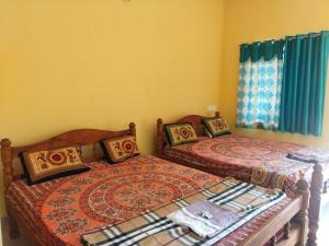 two beds sitting next to each other in a bedroom at Aasare Home Stay Gokarna in Kumta