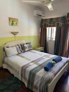 un dormitorio con una cama grande en una habitación en Casa Marina- Flic en Flac - Beach is right in front of the Villa-Just cross the road, en Flic en Flac