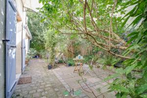 a small patio with a table in a garden at Orves - Seine-Saint-Denis - CI - Elegance and comfort with garden for 2 people in Le Pré-Saint-Gervais +4 photos