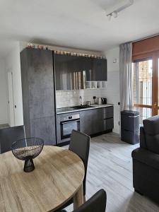 a living room with a table and a kitchen at Luca Apartment Rho in Rho