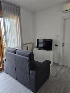 a living room with a couch and a television at Luca Apartment Rho in Rho