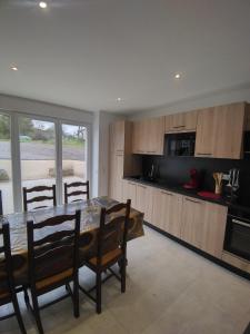 a kitchen with a table and chairs and a microwave at Gîte Pink House in Rainville