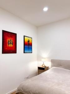 维也纳GG Immobilien-15 min to city centre的卧室的墙上装饰有三幅画