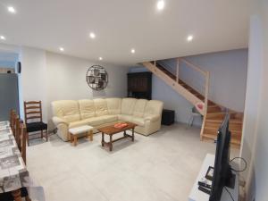 a living room with a couch and a staircase at Gîte Pink House in Rainville
