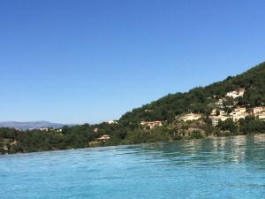 a view of a lake with houses on a hill at Le Mas de la Verrerie in Les Adrets de l'Esterel +2 photos