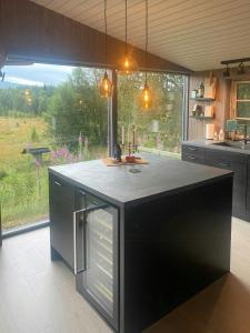 a kitchen with a black island in a kitchen with a window at Renovated Cabin With Views In Trysil in Ljørdal