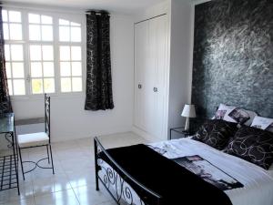 a bedroom with a black and white bed and a window at Le Mas de la Verrerie in Les Adrets de l'Esterel