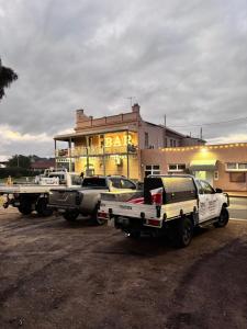 twee vrachtwagens geparkeerd op een parkeerplaats voor een gebouw bij The Club Hotel Collie in Collie +35 foto's