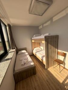 Cette petite chambre comprend 2 lits superposés et une chaise. dans l'établissement Three Lion Hotel, à Batoumi