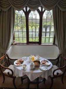 uma mesa com pratos de comida em frente a uma janela em Abbey Farm Bed And Breakfast em Atherstone