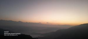 a sunset over a valley with mountains in the background at Saura Point Homestay in Nagarkot
