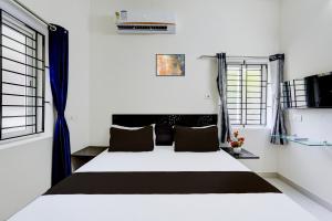 um quarto com uma cama em um quarto com janelas em Hotel O Elegant Residency Vandalur Zoo em Chennai mais 27 fotografias