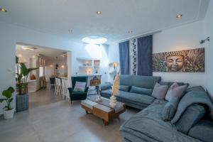 a living room with a blue couch and a table at 3 Paros All Season Villas in Parikia