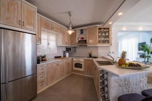 a kitchen with wooden cabinets and a bowl of fruit on the counter at 3 Paros All Season Villas in Parikia +102 photos