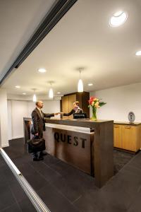 two men in an office with a post office at Quest Mounts Bay Road in Perth