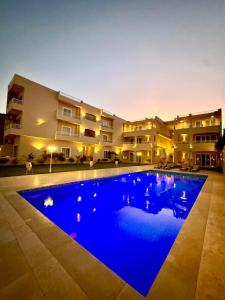 Una gran piscina azul frente a un edificio en Royal Nile Villa - Nile View Apartment 1, en Luxor