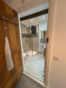 a bathroom with a shower and a glass door at Castle View Cottage at Snape Castle Mews in Bedale +13 photos