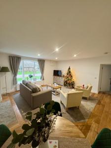 a living room with two couches and a christmas tree at Castle View Cottage at Snape Castle Mews in Bedale