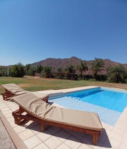 a swimming pool with two chaise lounges next to at Cuesta de san miguel in Chilecito