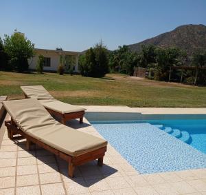 a pool with two chaise lounges next to a house at Cuesta de san miguel in Chilecito +70 photos