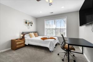 ein Schlafzimmer mit einem Bett, einem Schreibtisch und einem Computer in der Unterkunft Home in National Harbor Area in Accokeek
