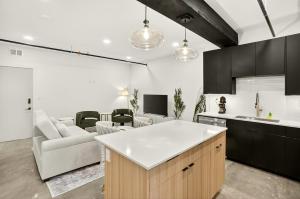 a kitchen with a white counter top and a living room at Downtown Tulsa Beacon Getaway in Tulsa