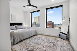 a white bedroom with a bed and a large window at Downtown Tulsa Beacon Getaway in Tulsa