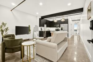 a living room with a couch and chairs and a kitchen at Downtown Tulsa Beacon Getaway in Tulsa