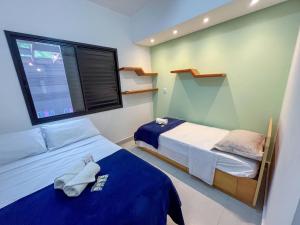 ein kleines Schlafzimmer mit zwei Betten und einem Fenster in der Unterkunft Casas Aconchegantes a 600m da Praia de Paúba in São Sebastião + 114 Fotos