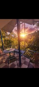 AnachalGreen porticos villa munnar #MUNNAR的阳台上的桌椅享有日落美景 更多75张照片