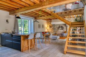 a kitchen and living room with a staircase in a house at Domaine Le Pineau Private Pool & Nordic Jacuzzi Loire Valley in Bléré