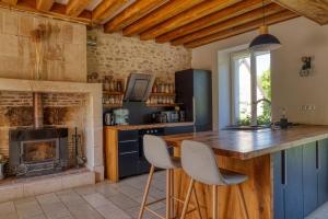 a kitchen with a bar and a fireplace at Domaine Le Pineau Private Pool & Nordic Jacuzzi Loire Valley in Bléré
